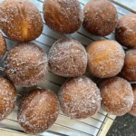 Freshly fried Taco Bell Cinnabon Delights cooling on a wire rack